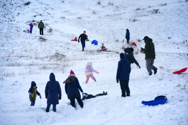People sledging and playing in the snow in Bannau Brycheiniog National Park 