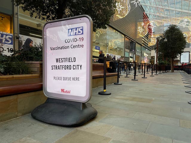 People queue at a COVID Vaccination Centre at the Westfield shopping centre in Stratford, east London