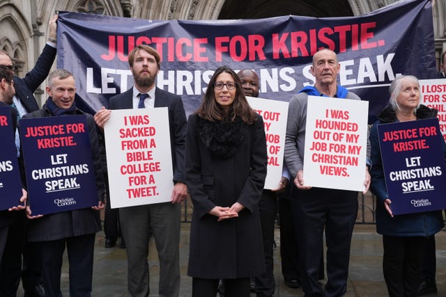 Christian school worker Kristie Higgs (centre) outside the Royal Courts Of Justice in London with supporters holding banners