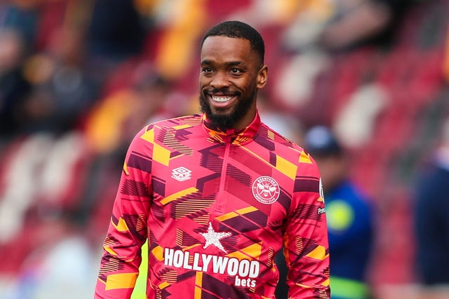 Ivan Toney smiles while warming-up in a Brentford training kit