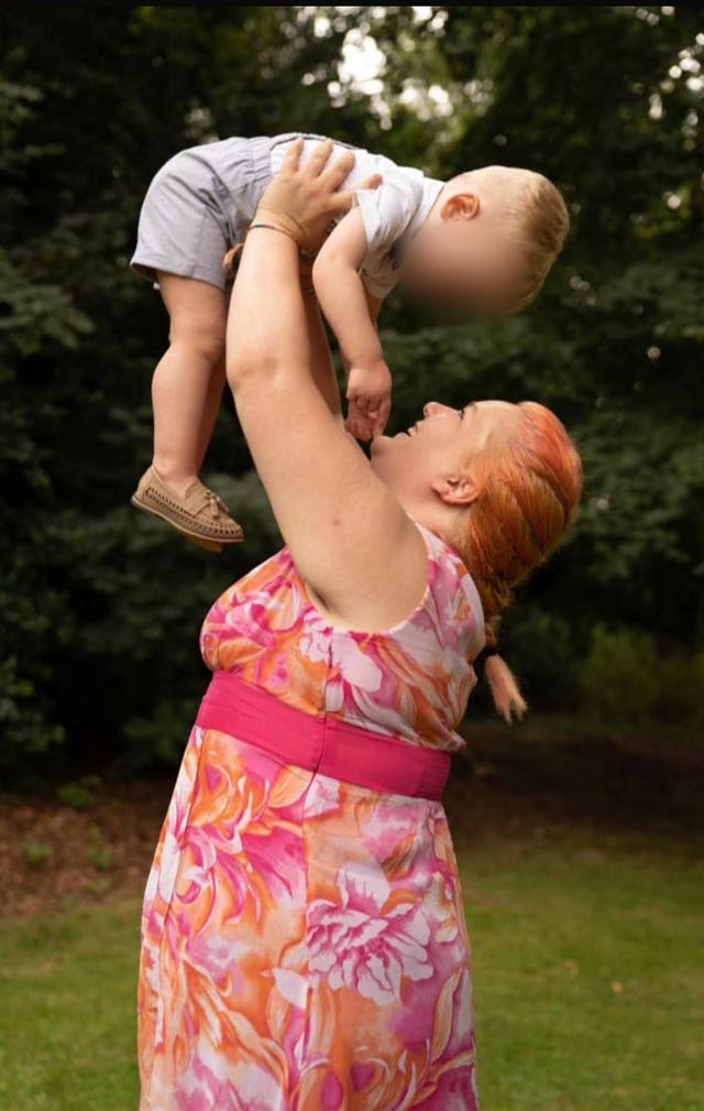 Handout photo of Rhiannon Whyte smiling while holding her young son up above her head
