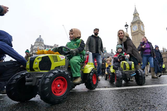 Children ride toy tractors during the farmers protest in central London