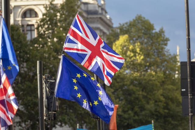 A Union flag and EU flag outside the Houses of Parliament London.