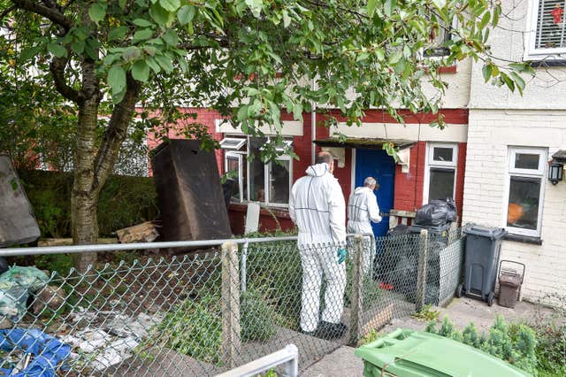 Police forensic officers enter the Cardiff property