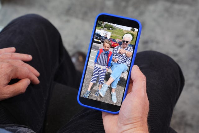 George Smith looks at a picture of his mother Maureen Smith on a mobile phone