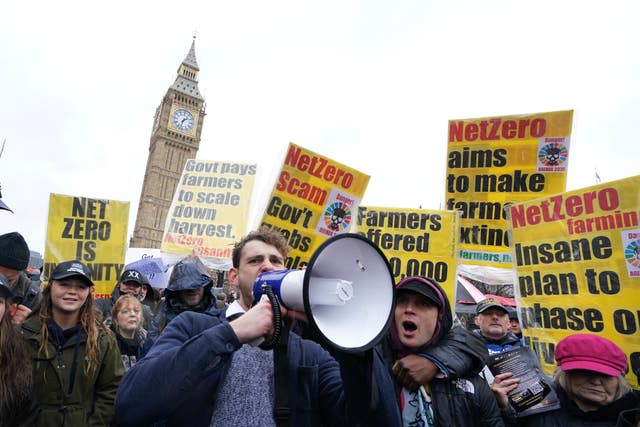 A man with a megaphone with a group of people backdropped by Big Ben