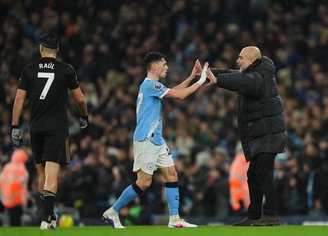 Manchester City manager Pep Guardiola celebrates with Phil Foden