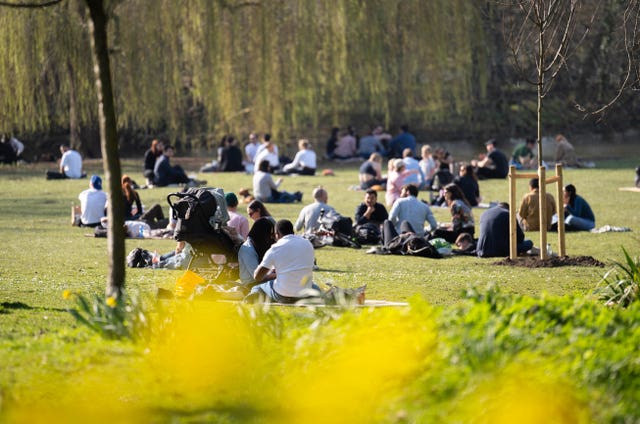 People sitting in the sun in Regent’s Park, central London