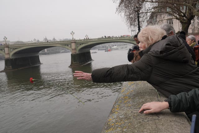 A woman throwing a rose into the Thames