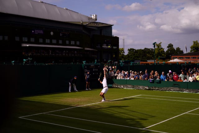 Jacob Fearnley serves in Centre Court's shadow