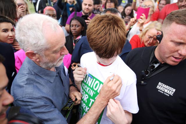 Labour Party leader Jeremy Corbyn signs a t-shirt 