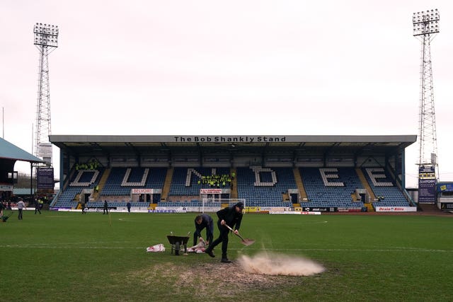 Ground staff work on the pitch before the inspection