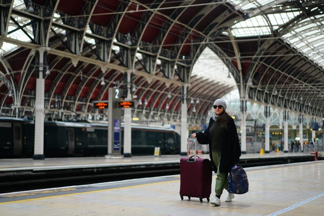 A woman with suitcases at an empty Paddington station in London during a strike by members of the Rail, Maritime and Transport union (RMT), in a long-running dispute over jobs and pensions 