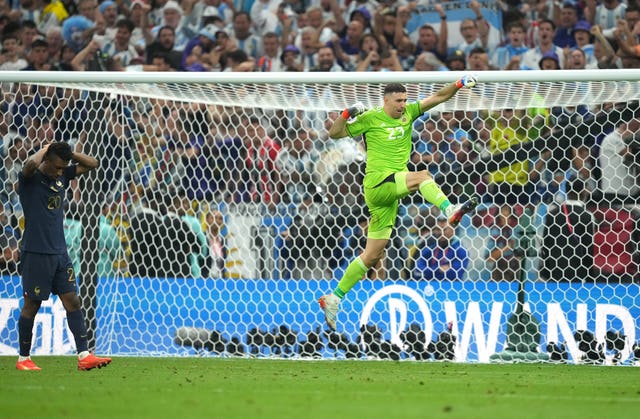 Emiliano Martinez, right, celebrates after saving Kingsley Coman’s penalty in the World Cup final penalty shoot-out