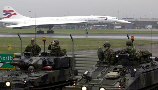 Troops look on as Concorde prepares to take off from Heathrow