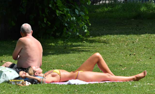 Sunbathers enjoy the hot weather in Victoria Park, east London as temperatures soared (John Stillwell/PA)