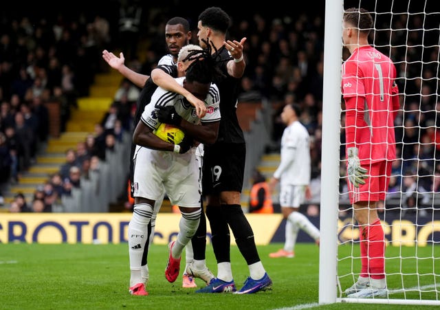 Fulham’s Calvin Bassey holds onto the ball as Tottenham’s Richarlison attempts to retrieve it for a quick restart after his goal for Tottenham