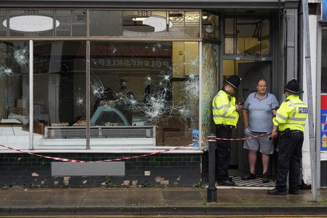 Police officers outside a damaged butchers shop on Murray Street in Hartlepool following a violent protest on Wednesday evening 