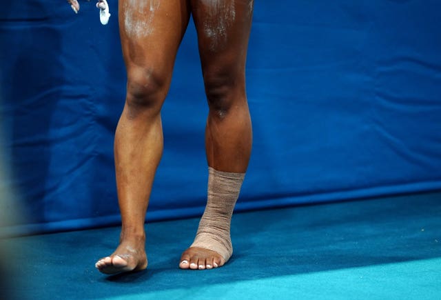 A close up picture of Simon Biles' legs, showing her left ankle strapped. 