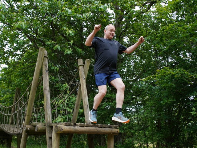 Sir Ed Davey jumps off a bridge on an assault course