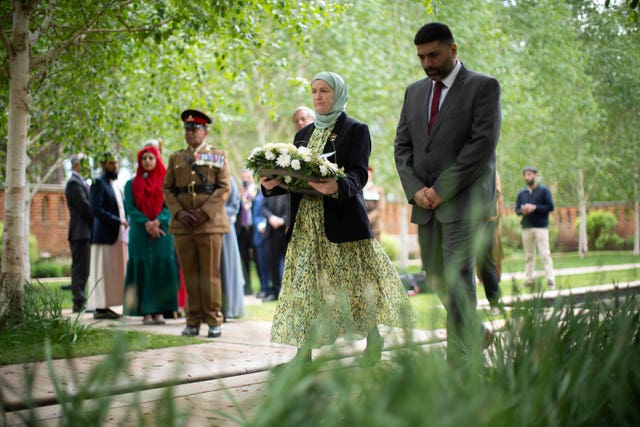 A person holding a wreath in the Peace Garden in Woking, ahead of a VE Day 80th anniversary interfaith afternoon tea party, at the Shah Jahan Mosque in Woking
