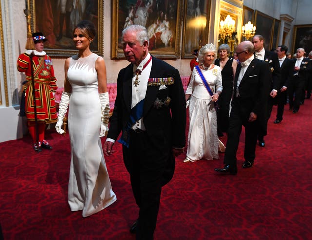 Melania Trump and the then-Prince of Wales arrive through the East Gallery during the State Banquet at Buckingham Palace