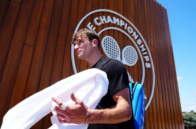 Jack Draper walks past the Wimbledon logo
