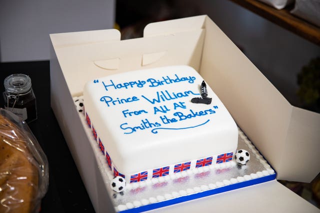 The Duke of Cambridge is presented with a birthday cake by shop owner Paul Brandon during a visit to Smiths the Bakers, in the High Street in King’s Lynn, Norfolk 