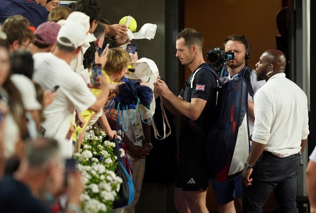 Andy Murray signs autographs for fans before leaving the court 