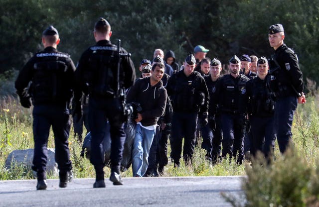 French police officers move migrants on from a camp in Calais