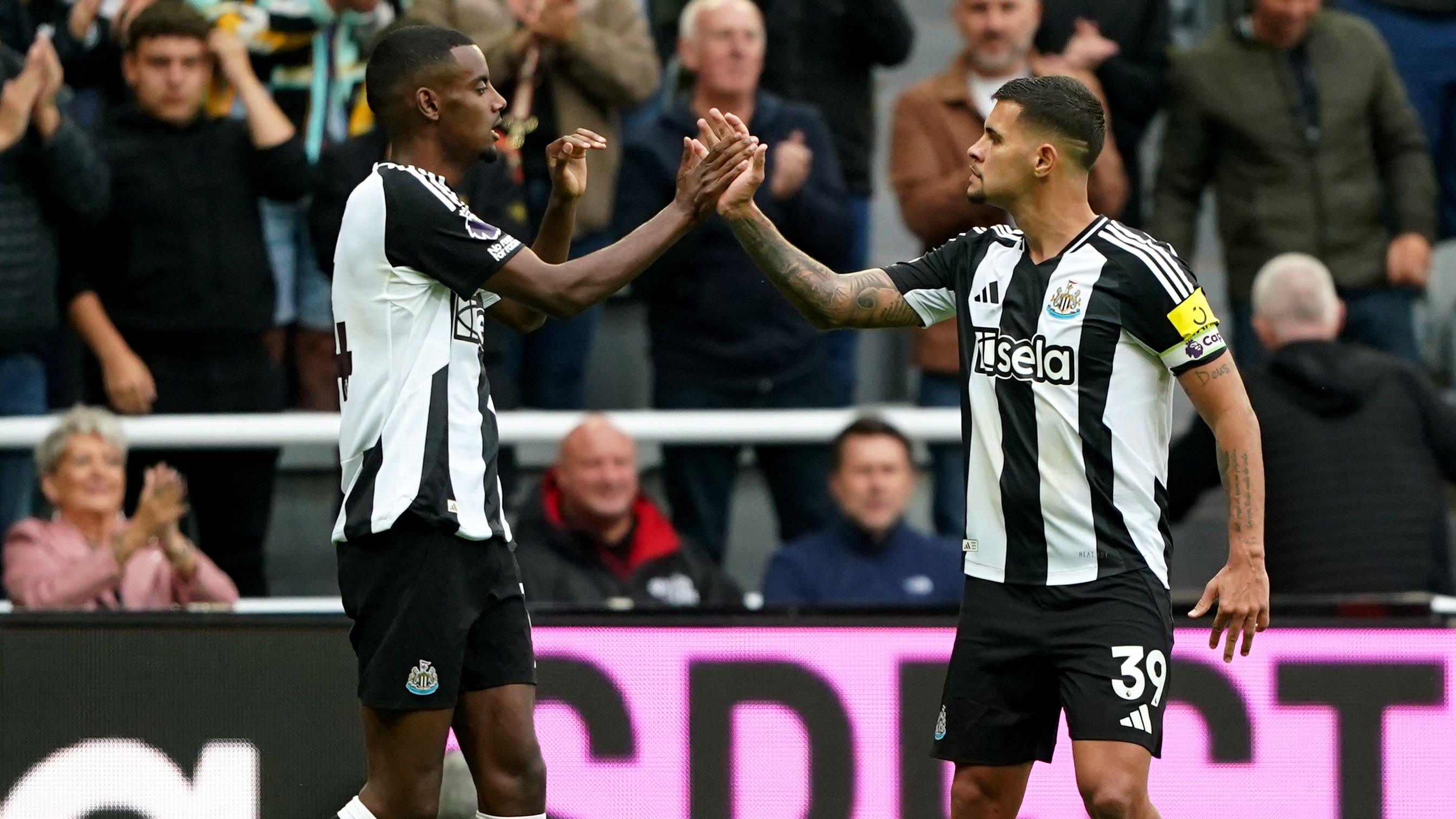 Alexander Isak, left, celebrates his winner with Newcastle captain Bruno Guimaraes (Owen Humphreys/PA)