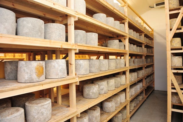 Cheeses mature in a store room (Ben Birchall/PA)
