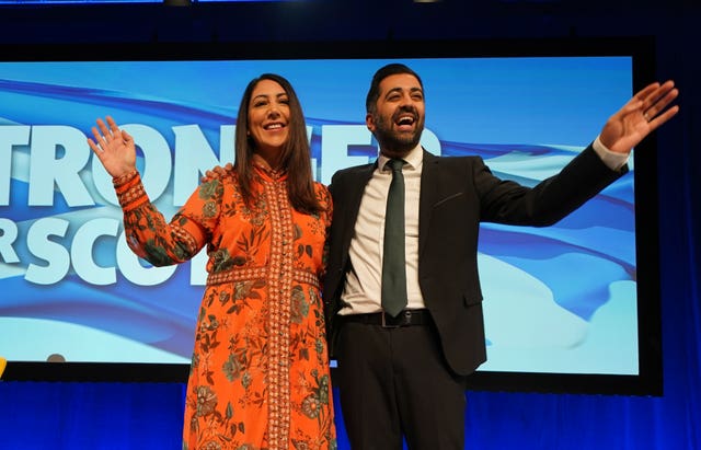 Nadia El-Nakla and Humza Yousaf waving from SNP conference stage