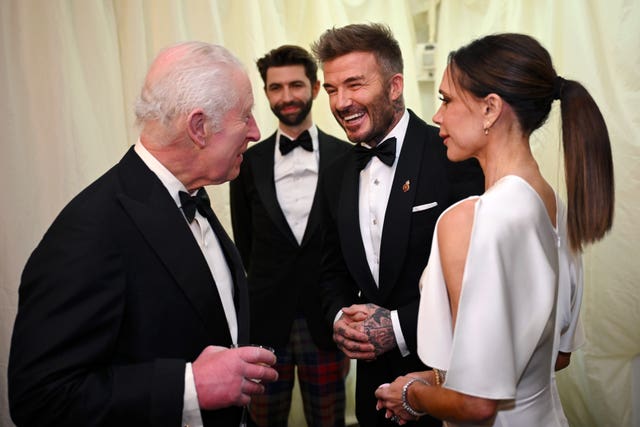 The King speaks to David Beckham and Victoria Beckham. 