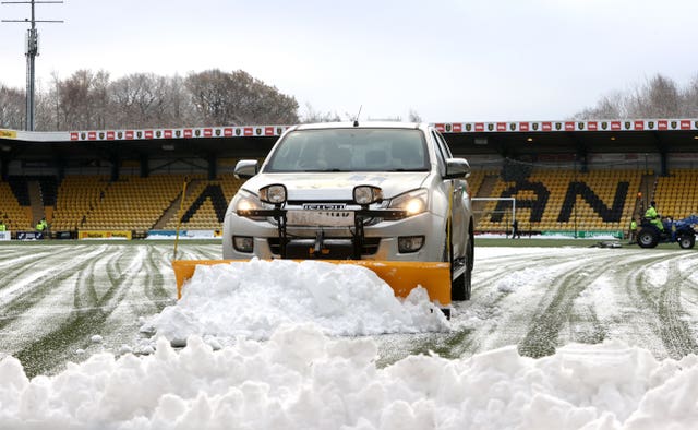 Snow is cleared from a football pitch