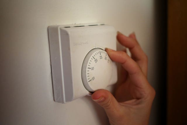 File photo dated 19/09/13 of a person using a central heating thermostat