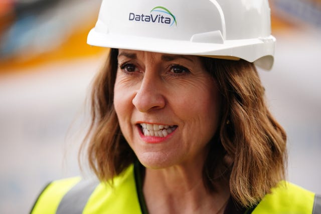 Liz Kendall speaking, while wearing a hard hat and hi-vis vest