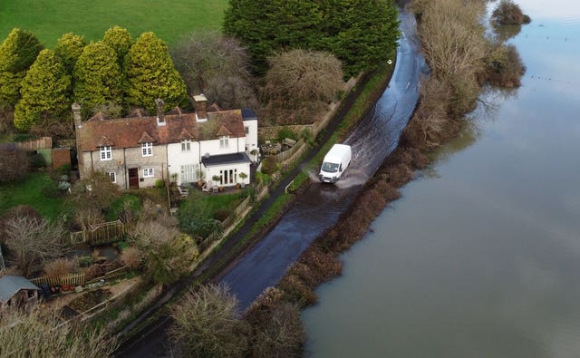 A car passes through flood water from the Cuckmere River in Alfriston, East Sussex 