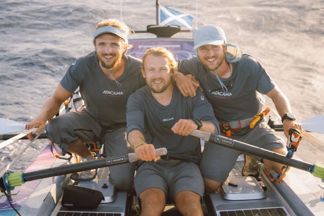 Lachlan, Jamie and Ewan Maclean smiling while in their rowing boat