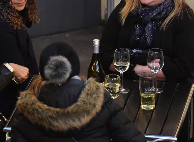 A group of women drinking white wine outside a bar