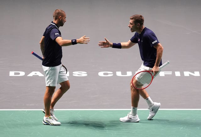 Dan Evans, left, and Neal Skupski touch hands