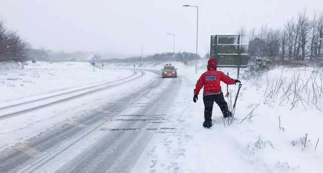 A member of the North Dartmoor Search and Rescue Team watches a motorist driving along a road near Okehampton (Martin Keene/PA)