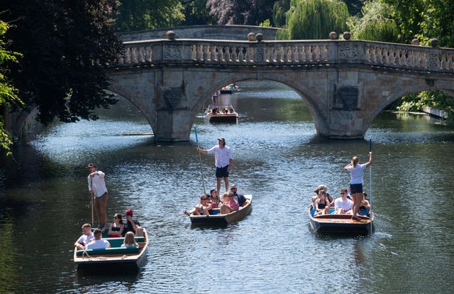 People enjoy the hot weather during a punt ride along the River Cam in Cambridge (Joe Giddens/PA)