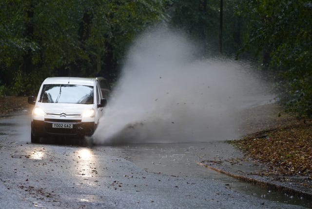 A car drives near part of a flooded road in Liverpool