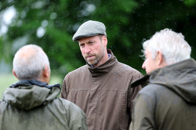 William, wearing a flat cap, talks to two other men on Dartmoor