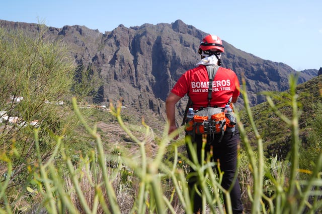 A firefighter looks over the village of Masca, Tenerife, in the search for Jay Slater