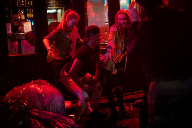Late-night drinkers in Soho dance on the street in the early hours of Sunday morning