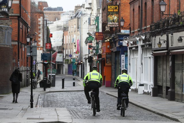 Garda ride through the quiet Temple Bar area of Dublin on St Patrick’s Day (Brian Lawless/PA)