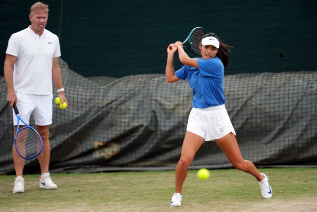 Emma Raducanu hits a backhand as coach Mark Petchey watches on the practice court