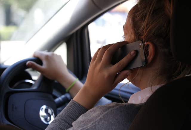 A driver holding a mobile phone